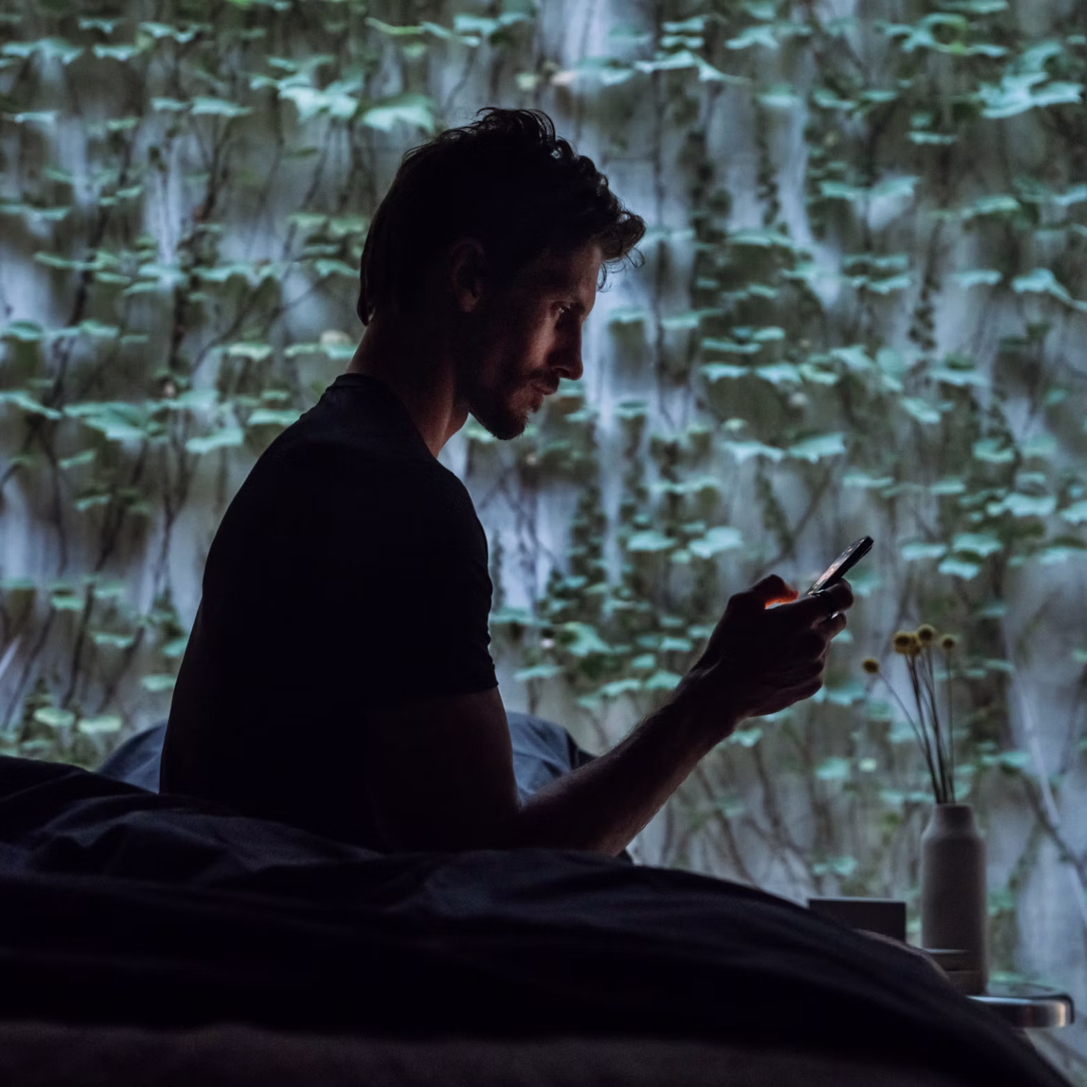 Homme qui démarre sa journée en consultant l'application Oura