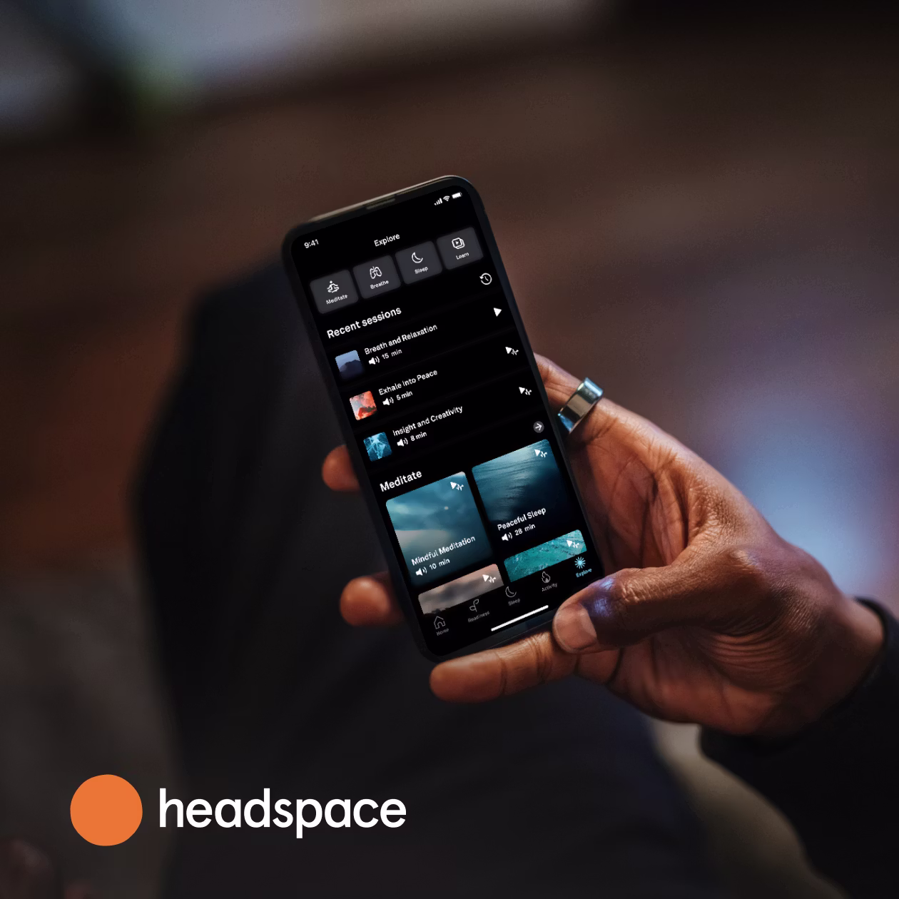 Personne tenant un smartphone dans la main droite avec l'application Headspace ouverte et la KEORA Ring à l'index droit