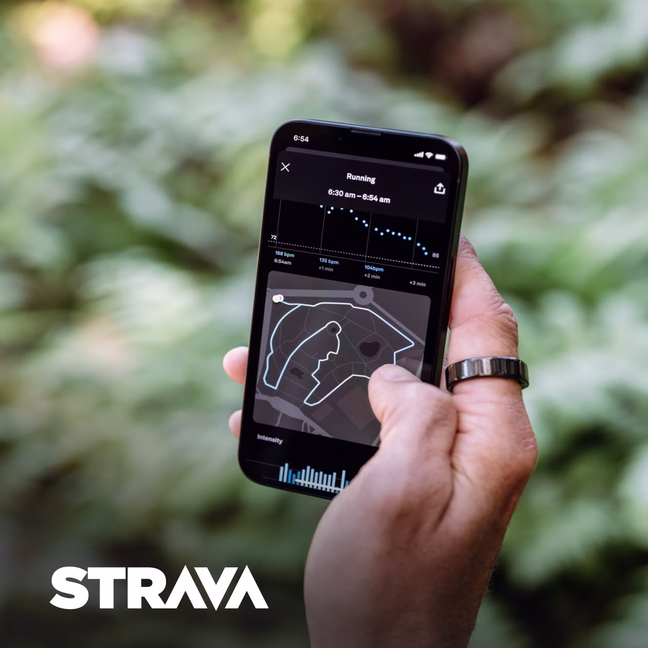 Personne tenant un smartphone dans la main droite avec l'application Strava ouverte et la KEORA Ring à l'index droit